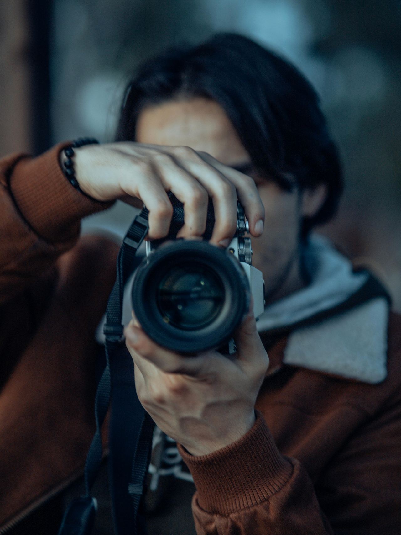 A photographer focused on the moment, framing through the lens with intent